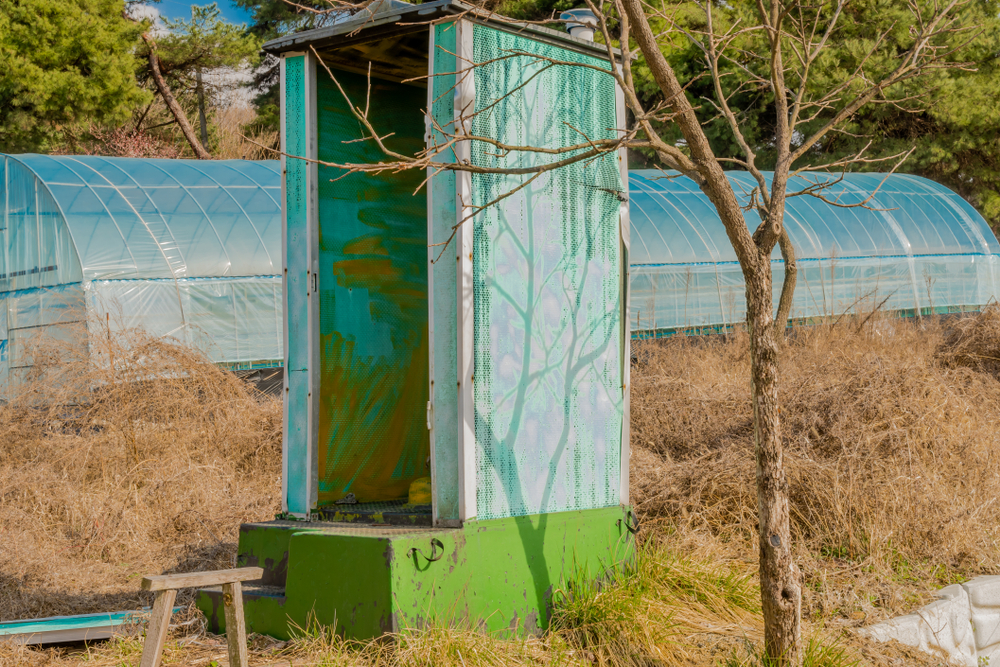 Old portable bathroom in park